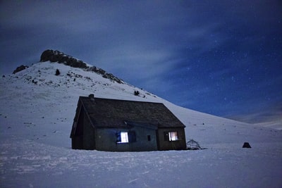 灰色的木屋在积雪覆盖的地上蓝天白天
